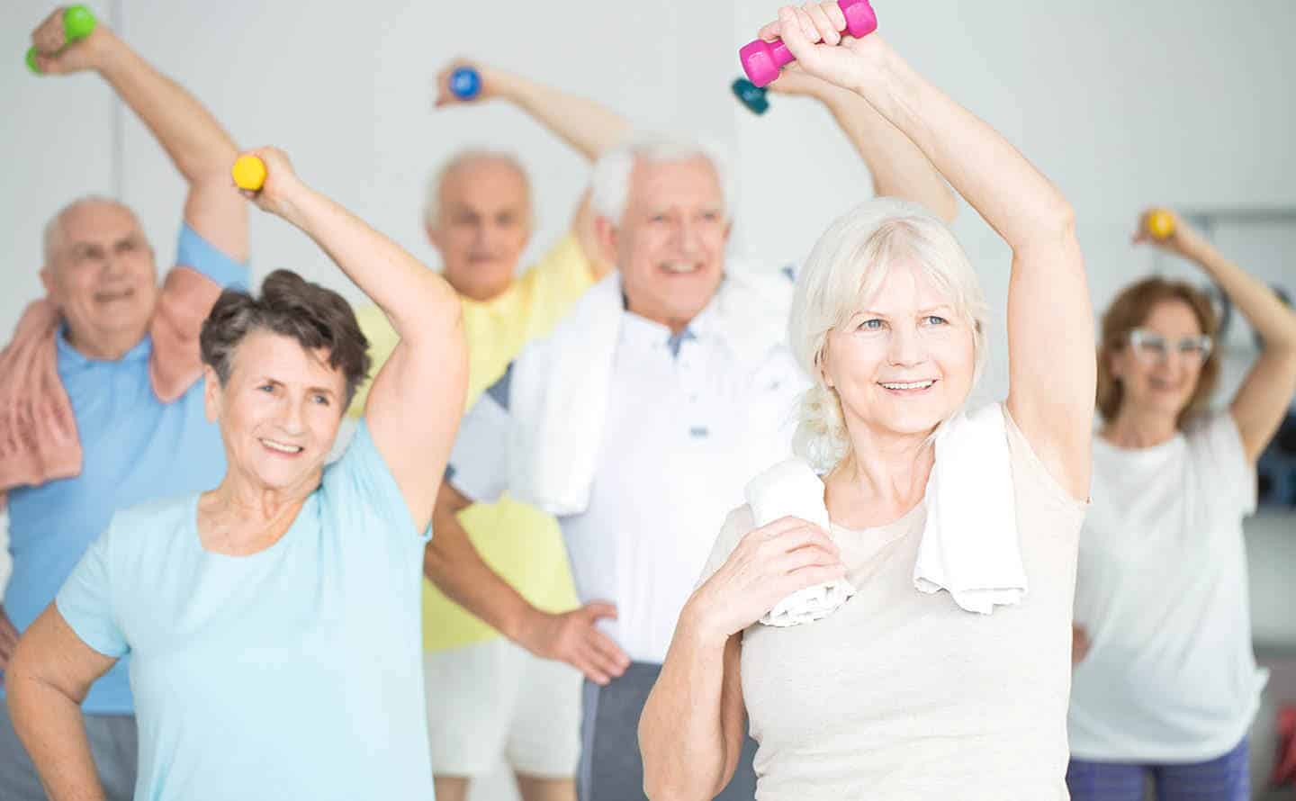 Seniors in a group exercise class with weights in hand