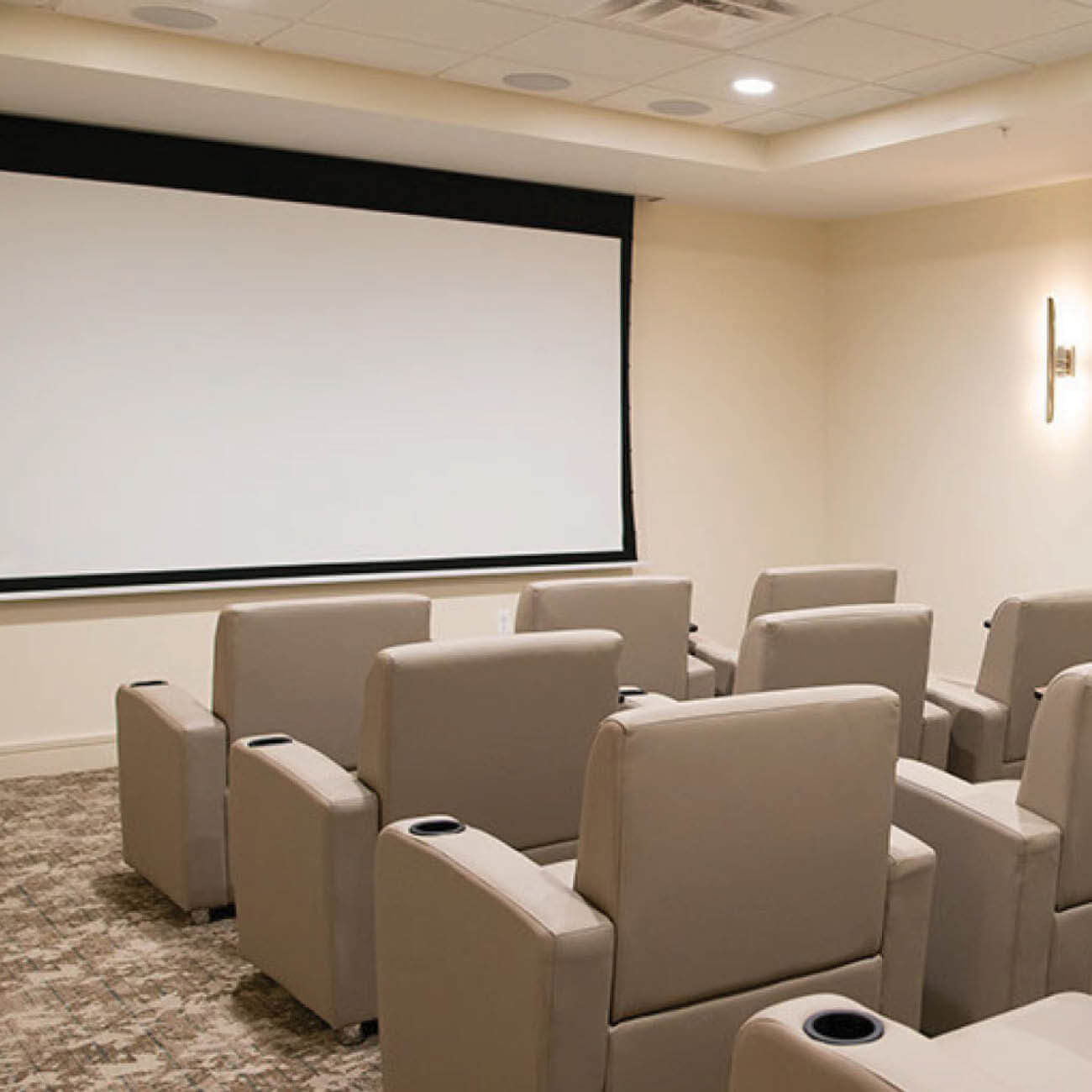 Theatre room at Highpoint at Cape Coral. Includes many reclining leather movie theatre seats and a large projector screen.