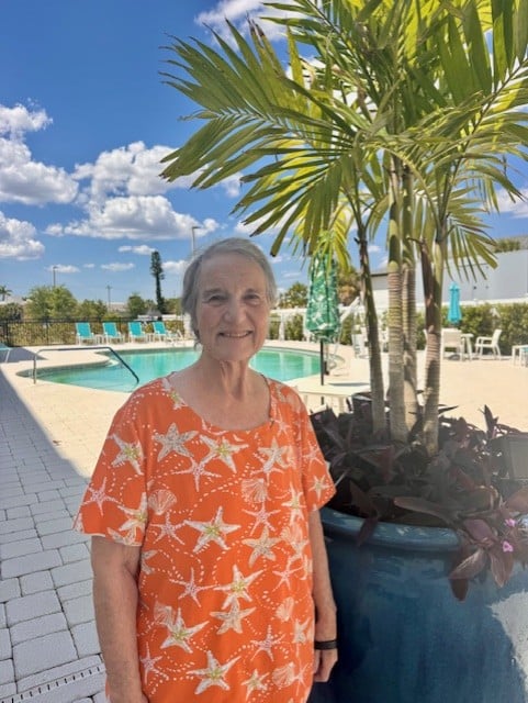 Smiling resident standing by the pool